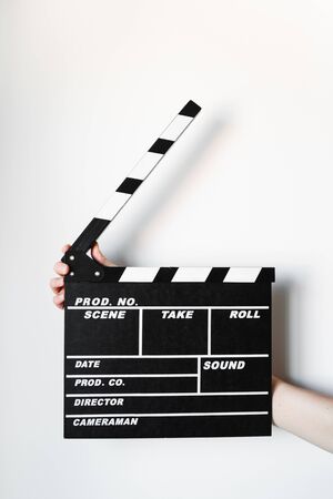 Female hand holding movie clapper isolated on whiteの写真素材