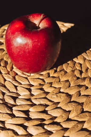 Beautiful isolated red apple illuminated on tablemats