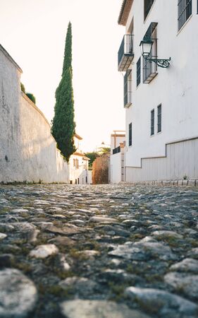 Beautiful empty arabic street with pavement and vertical tree at sunset. Typical streets of southern spainの写真素材