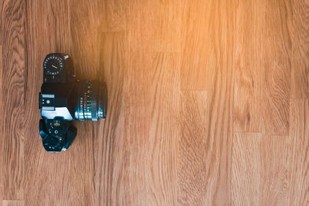 Black analog camera on wooden desk. Top viewの写真素材
