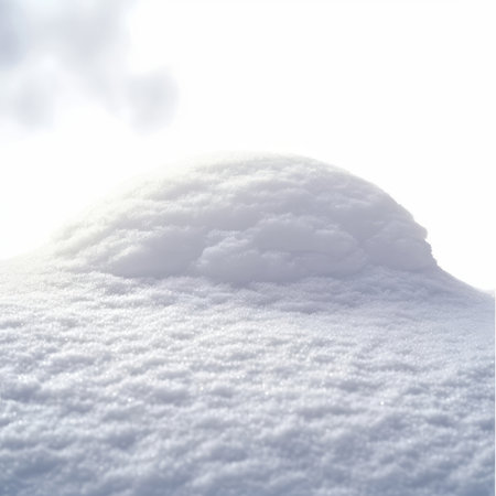 A massive accumulation of snow resting atop a hill, forming a prominent mound.の素材