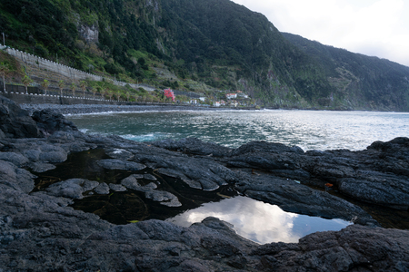 Beautiful black rock beach in Seixal, Madeira with waves crashingの写真素材
