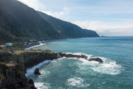 Beautiful black rock beach in Seixal, Madeira with waves crashingの写真素材