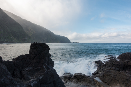Beautiful black rock beach in Seixal, Madeira with waves crashingの写真素材