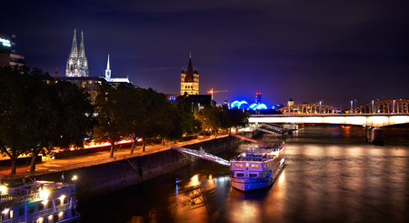 View of Cologne Dom Cathedral and Great St Martin Church at night from the chocolate museumの写真素材