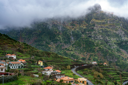 Village and beautiful mountains with clouds, in Madeiraの写真素材
