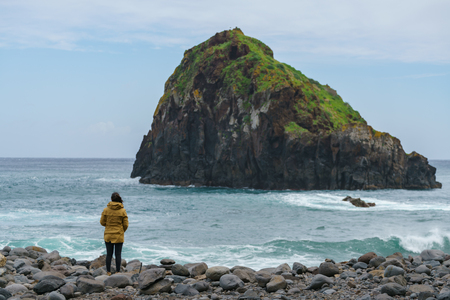 Woman looking at Ribeira da Janela islet in Madeiraの写真素材