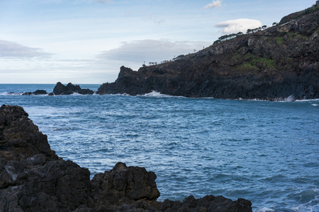 Seascape with waves crashing on the rocks in Seixal, Madeiraの写真素材
