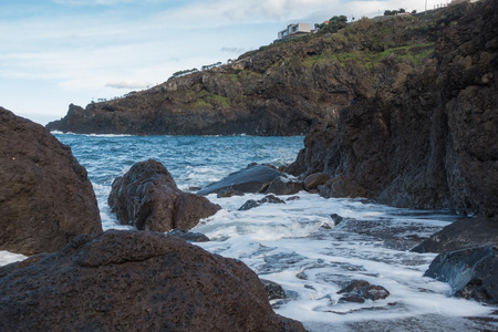 Seascape with waves crashing on the rocks in Seixal, Madeiraの写真素材