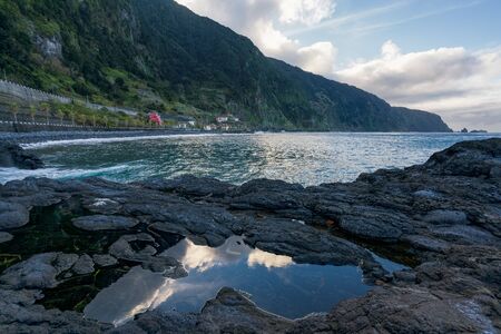 Beautiful black rock beach in Seixal, Madeira with waves crashingの写真素材