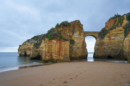 Praia dos estudantes beach with arch bridge in Lagos, Portugalの写真素材