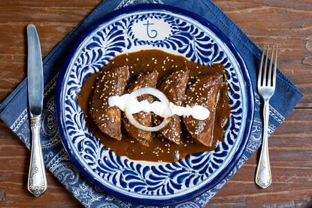 Traditional mexican cuisine mole enchiladas served on talavera plateの写真素材