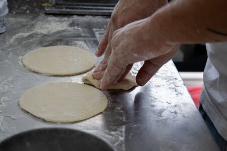 Hands making dough for argentinian empanadasの写真素材