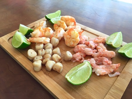 Grilled seafood pieces on the wooden table with lemon slicesの写真素材