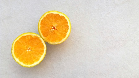 Two halves of an orange on light backgroundの写真素材