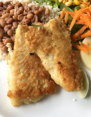 Two grilled fish fillets with rice, beans and saladの写真素材