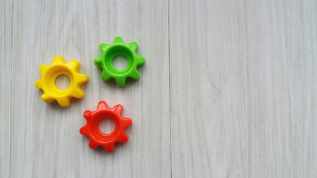 Plastic colorful toy gears on wooden backgroundの写真素材