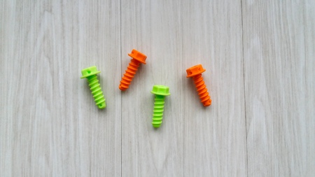 Plastic colorful toy screws on wooden backgroundの写真素材