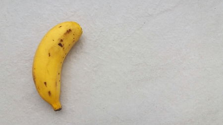 A single banana isolated on a light backgroundの写真素材