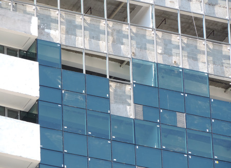 Glasses being installed on the facade of a building under constructionの写真素材