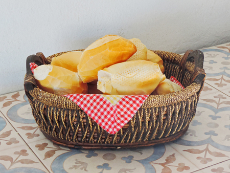 Fresh breads in a basket on the tableの写真素材