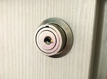 Metal round lock in a wooden cabinet