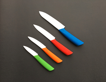 Set of colored knives on dark backgroundの写真素材