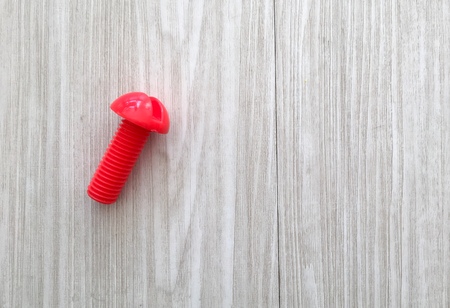 A plastic toy screw on a wooden surface