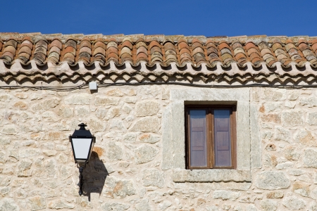 Facade made of stone, window and lamp in a rustic houseの写真素材