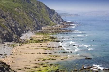 Rocky beach with sand close to a mountainの写真素材