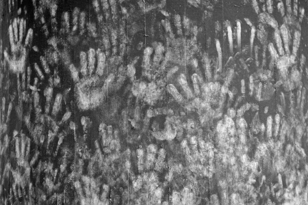 White hands imprints on a black colored wallの写真素材