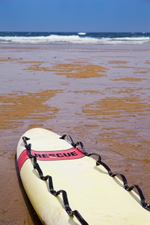Lifeguard surfboard with the tittle rescue on the beach close to the shoreの写真素材