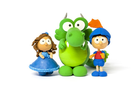 Handmade toy dolsl and green dragon on white made with modelling clayの写真素材
