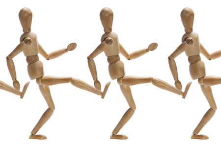 Wooden mannequins kicking each other in the backsideの写真素材