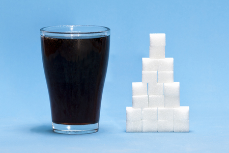 Sugar cubes with cola as a concept of too much sugar in the drinkの写真素材