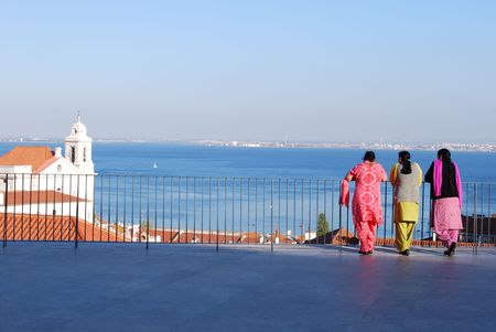 indian women looking at the river Tagus in Lisbon, Portugalの写真素材