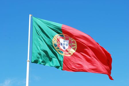 portuguese flag against blue sky backgroundの写真素材
