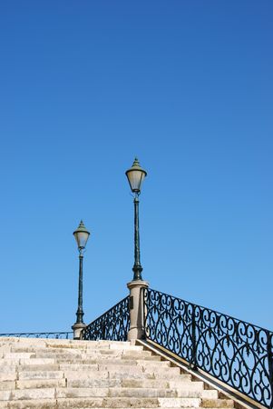 beautiful close up of a typical stairway made of calcada pavement with a gorgeous retro lamp postの写真素材