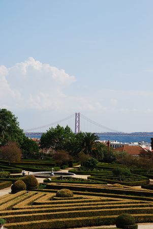beautiful ornamental Ajuda garden with April 25th bridge on background in Lisbon, Portugalの写真素材