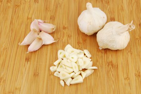 all, chopped and slices of garlic on a wooden cutting boardの写真素材