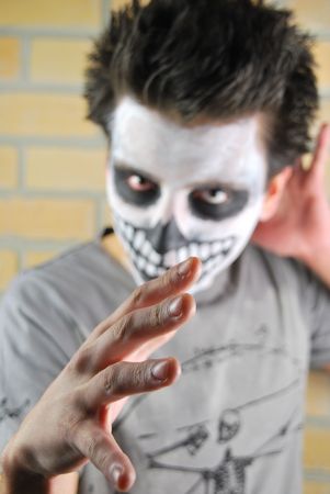 Evil look and hand, portrait of a creepy skeleton guy perfect for Carnival (brick wall background)の写真素材