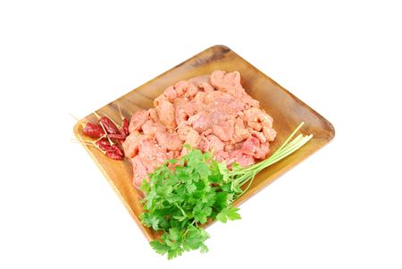 raw pork meat with red pepper and parsley ready to be cooked on a wooden tray (over white)
の写真素材