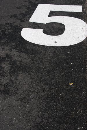 white 5 number sign painted on the asphalt roadの写真素材