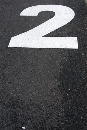 white 2 number sign painted on the asphalt roadの写真素材