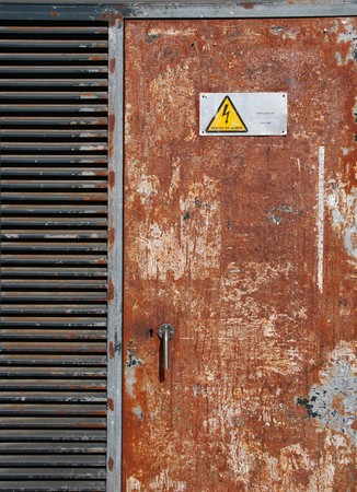 danger high voltage sign on a rusty metal doorの写真素材
