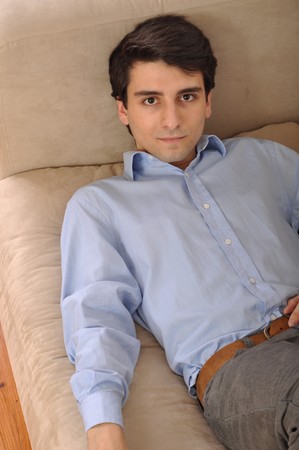 attractive young man lying and relaxing on the couchの写真素材