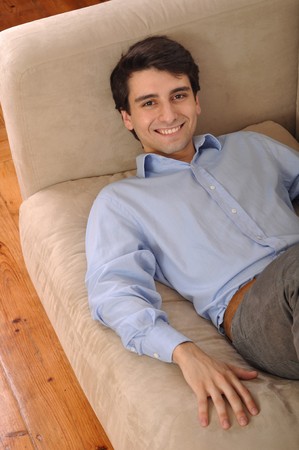 attractive young man lying and relaxing on the couchの写真素材