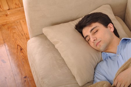 attractive young man sleeping on the couchの写真素材