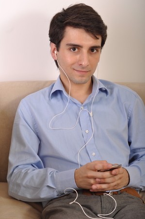 attractive young man listening to music on the couchの写真素材