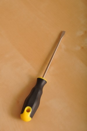screwdriver with plastic handler on a brown wooden backgroundの写真素材